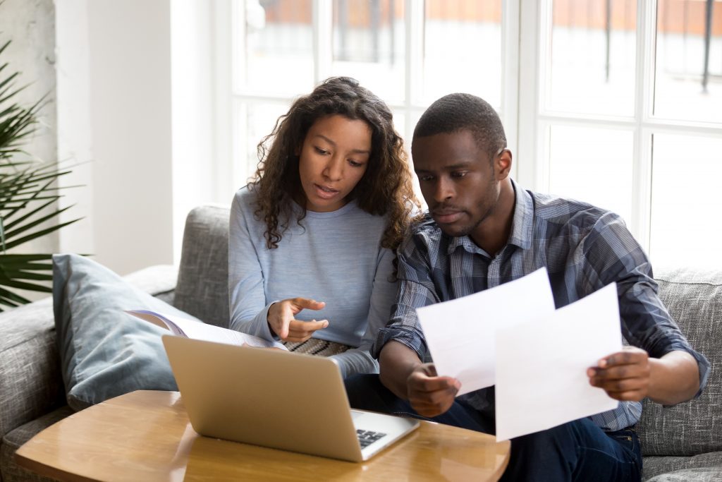 young couple looking at laptop assessing eligibility for eco flex scheme