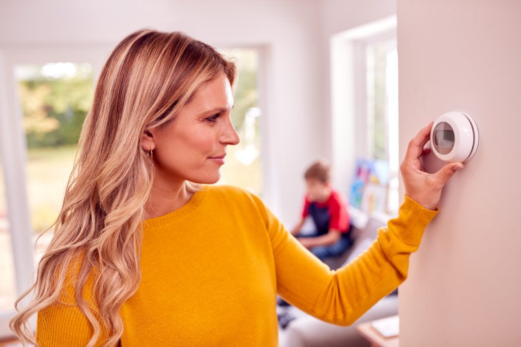 woman altering smart thermostat