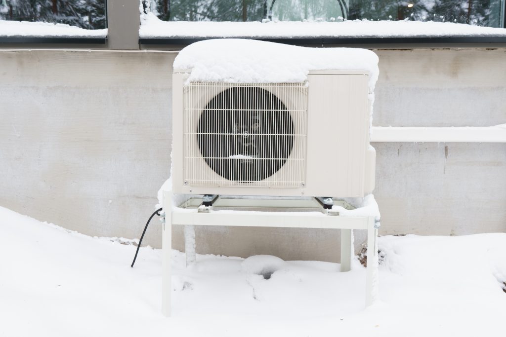 The outdoor unit of an air source heat pump after a winter storm.