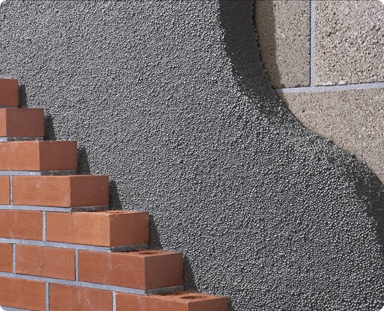 Cavity wall insulation beads being installed into a brick exterior wall