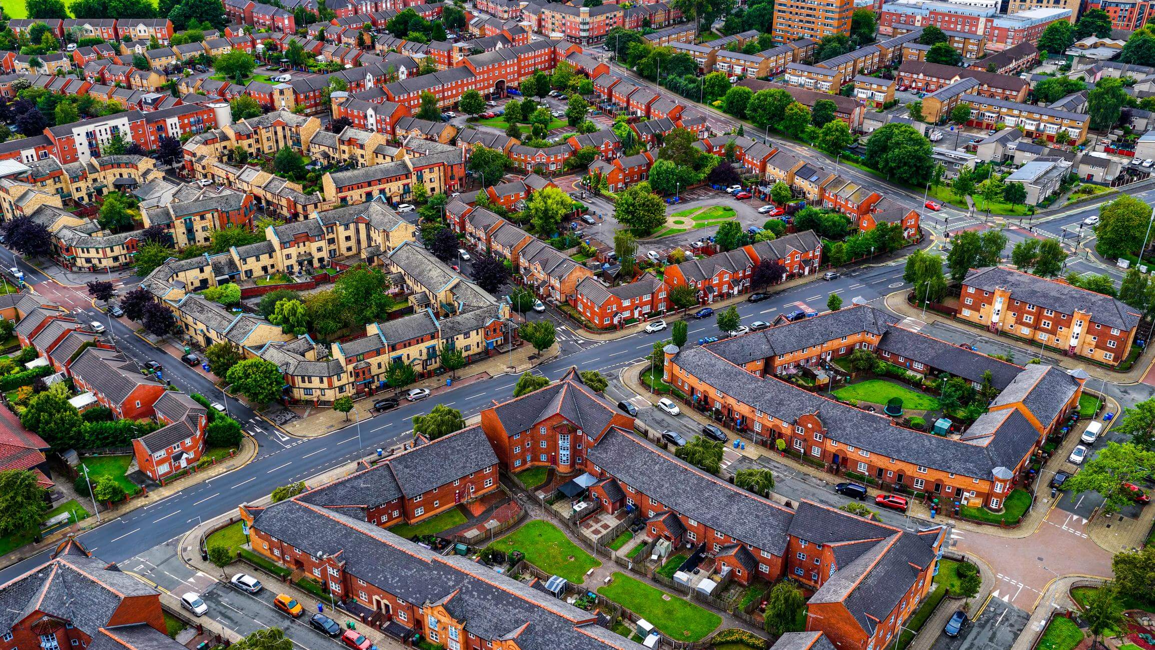 Aerial view of Hulme residential housing estate in Manchester with rows of terraced houses, urban neighborhood streets and green courtyards, Northwest England suburban city planning concept for real estate and housing development