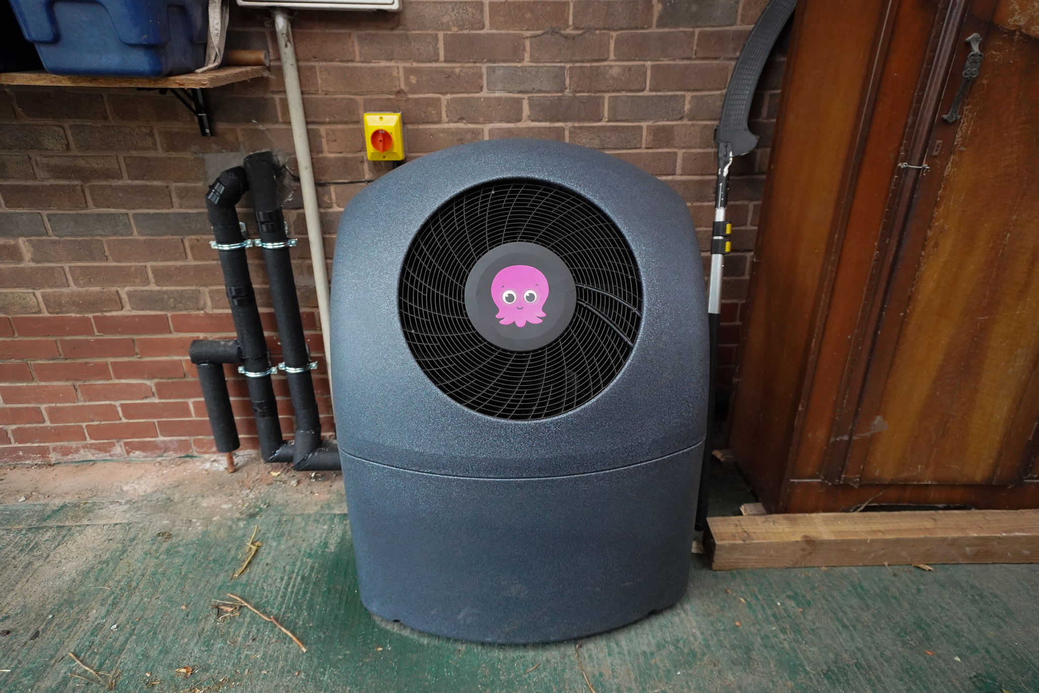 Front view of an outdoor Octopus Cosy heat pump unit showing the central circular fan grill and octopus logo.